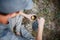 Outdoors image of young explorer man drinking hot beverage in mountains, sitting and relaxing after trekking