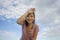 Outdoors jogging - young happy and dedicated Asian Chinese woman happy and tired after running workout posing under a blue sky