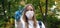 Outdoors portrait of beautiful young woman wearing cotton white mask and medicalgloves greeting and say hello, Nature and trees in