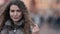 Outdoors portrait of charming curly haired woman at winter, snow is falling on her, closeup portrait