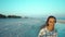 outdoors portrait of happy attractive mixed race woman enjoying walk on wild sea sand beach at sunset with beautiful