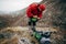 Outdoors shot of traveler bearded man preparing tent camping gear in mountain. Young male explorer hiking in mountain.