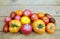 Outdoors still life with ripe red and orange tomatoes on brownn wooden table surface as background
