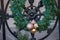 Outdoors Winter Holiday decoration concept: Natural Christmas Wreath with Colorful Balls decorating iron fence. Winter Holiday