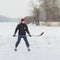 Outdor portrait of young hokey player with stick on a frozen river Dnepr