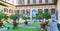 Outer courtyard of the Medici Riccardi Palace, which has an Italian garden with statues and tubs with plants.