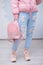 Outfit of casual woman. Jeans, leather backpack, pink sneakers isolated on grai background.
