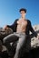 Outfit young man. Open shirt and muscular body. On the rock