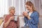 Outgoing grandma and woman drinking beverage