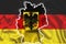 Outline map of Germany against the background of a waving textile German flag. 3D illustration