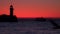 Outlines of a mole with a lighthouse and a ship against the backdrop of dawn