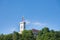 Outlook tower, also called viewing tower or Razgledni stolp, taken from downhill in Ljubljana castle with the flag of the city.