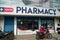 Outside, exterior view of the Porvoo Pharmacy store, as a customer on a motorbike drives by