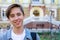 Outside portrait of teen boy. Handsome teenager carrying backpack on one shoulder and smiling.