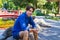 Outside portrait of young smiling man in park. Teenager having rest in park.