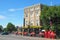 The outside view of the Mitre Hotel in Greenwich, London on a summer day with the red telephone boxes and people passing by.