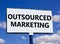 Outsourced marketing symbol. Concept words Outsourced marketing on beautiful white billboard. Beautiful blue sky white cloud