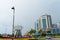 Outstanding stainless steel public art, sculpture on vehicle roundabout in Kota Kinabalu with colorful gardens and city backdrop