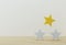 Outstanding yellow star shape on wooden table and white background. The best excellent business services rating for satisfaction