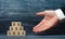 The outstretched hand of a businessman points to a pyramid of wooden squares with dollar symbols. Concept promoter, sale