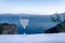 Ouzo stemmed glass against sea with santorini caldera