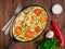 Oval cast iron pan with delicious hot omelette with tomatoes and