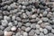 Oval lava stones thrown from the sea ashore. Sea-worked boulders of gray and black. Natural building material. Lava stones