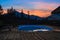 Oval open-air swimming pool high in the mountains against the backdrop of the beautiful summer sunset and mountains. The