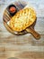 Oval Shape Cheesy Flatbread with Salsa Dip on a Round Wooden Pizza Board with Handle on a Wooden Table