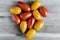 Oval tomatoes of yellow and red color on a wooden background