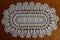 Oval white crochet lace handmade doily on wood