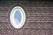 Oval window in brick wall