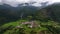OVARO MIONE, ITALY - APRIL, 2023: Aerial drone view of a valley in the morning with clouds. Small mauntain village Mione