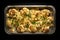 Oven baked Cauliflower Cheese in a Foil Tray on a dark background