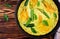 Oven baked omelette with flowers zucchini in pan on wooden background