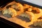 Oven-baked sugar-frosted croissants on a baking sheet covered with parchment paper. Sweet bagels from a cottage cheese dough baked