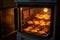 oven door open, revealing golden baked biscuits