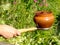 Oven fork and clay pot in woman hand.