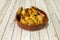 Oven roasted minced chicken in an earthenware bowl accompanied by french fries