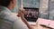 Over businessman shoulder laptop view partners involved in videoconference negotiations