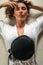 Over head portrait view of an beautiful young woman laying down in her expensive villa with luxuty python bag. Have curly hair,