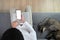 Over head shot of young man using emty screen smart phone and sitting with his cat on sofa.