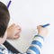 Over shoulder view of a young boy drawing