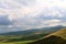 overcast clouds cloudscape sky lush green rainy rolling mountain hills landscape background