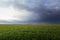 overcast clouds over a green field