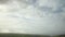 Overcast gray clouds are flying fast in the sky over a green area in Ireland, accelerated timelapse video