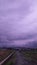 overcast purple sky full of clouds with views of rice fields and mountains
