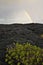 Overcast Sky with Rainbow and Black Lava