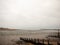 An overcast summer scene beach groynes pebbles mudflats