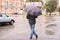 Overcast weather. Blurred Background. Man with black umbrella